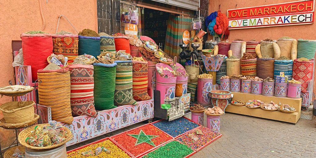 Étal coloré d'épices et de pigments dans un souk marocain à Marrakech