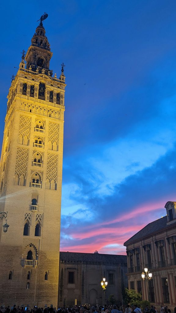 La tour Giralda de Séville illuminée au coucher de soleil, ciel rose et bleu