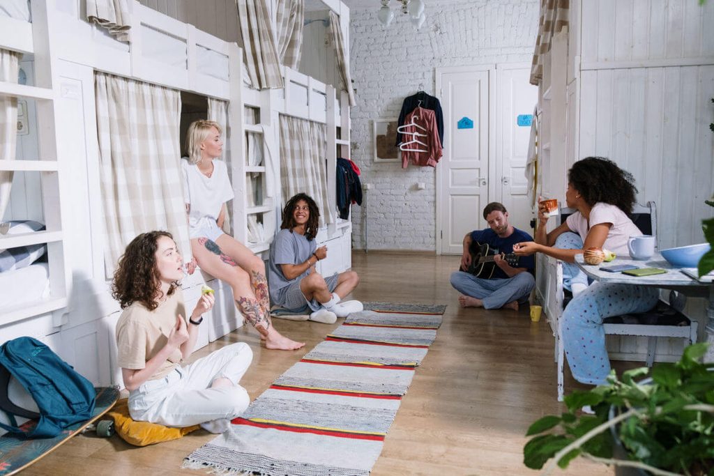 Groupe de voyageurs partageant un moment convivial dans le dortoir d'une auberge de jeunesse